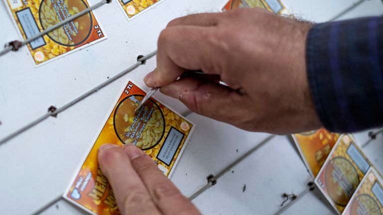 A man scratching ticket of Turkish lottery in the street at the stand of a lottery ticket seller. Pic: iStock