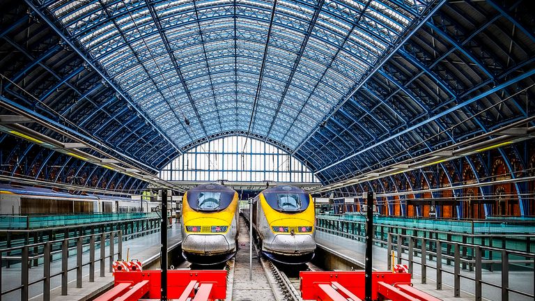 London, United Kingdom - August 30, 2015: Two huge bright red steel buffer stops protect the Eurostar terminus at St Pancras Station in London as three trains wait in platforms for their turn to take passengers on the high speed journey to Paris via the Chunnel. Opened in 1868, this masterpiece of Gothic architecture underwent a magnificent restoration completed in late 2007.