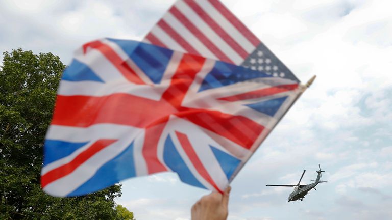 A woman waves British and U.S. flags as she watches Marine One helicopter, with President Donald Trump and first lady Melania Trump aboard, liftoff from Winfield House, residence of the US Ambassador, before boarding Marine One helicopter for the flight to nearby Blenheim Palace, Thursday, July 12, 2018 in London. (AP Photo/Pablo Martinez Monsivais)