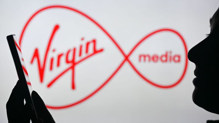 Set  14458640    Image  14458640bo    Photographer  Artur Widak/NurPhoto/Shutterstock    Photo Illustrations - Stock Pictures, Edmonton, Canada - 28 Apr 2024  EDMONTON, CANADA - APRIL 28: An image of a woman holding a cell phone in front of the Virgin Media logo displayed on a computer screen, on April 29, 2024, in Edmonton, Canada.    28 Apr 2024