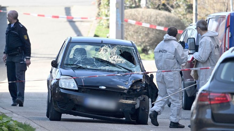 Forensics officers examine a damaged car on an access road to the Rhine bridge.  Pic: DPA/AP