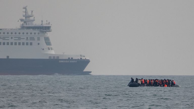 An inflatable dinghy carrying migrants passes a passenger ferry as it makes its way towards England in the English Channel, Britain, August 6, 2024. REUTERS/Chris J. Ratcliffe