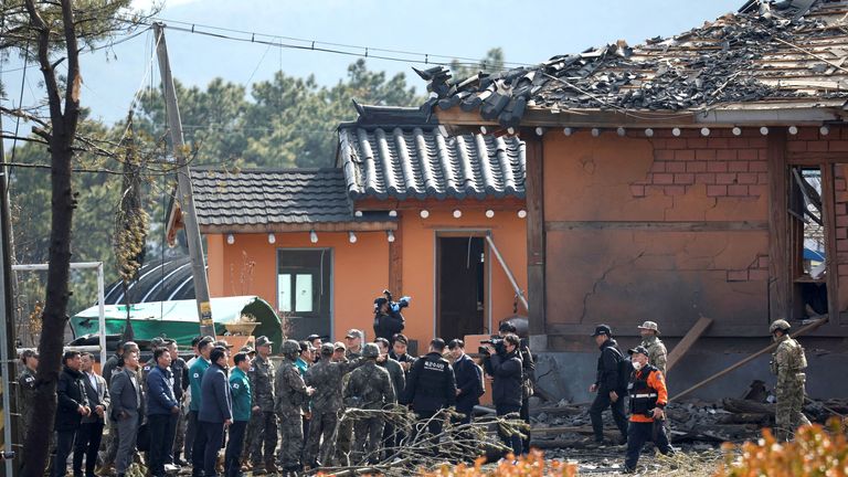 Officials examine near damaged buildings.  Pic: Reuters