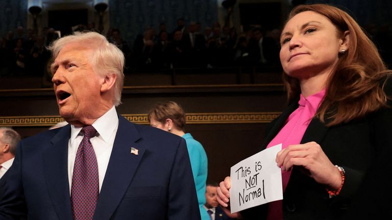 Democrat Melanie Stansbury held up a sign that said 'This is not normal'. Pic: Reuters
