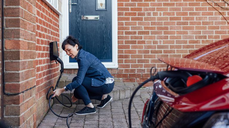A woman charges her EV at home. File pic: iStock