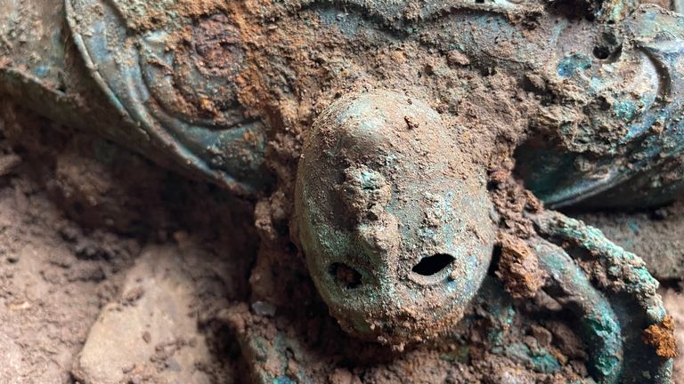 A mask-like decorative human face found as part of the Melsonby hoard of Iron Age artefacts. Pic: Durham University / PA