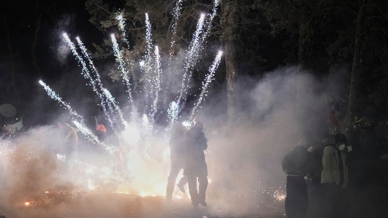 A firework launched by protesters as they clash with riot police during a protest against the arrest of Istanbul's Mayor Ekrem Imamoglu, in Istanbul, Turkey, Saturday, March 22, 2025. (AP Photo/Francisco Seco)