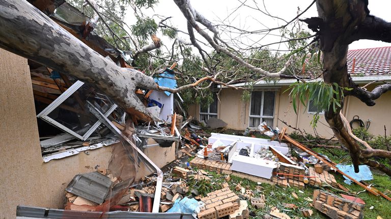 Debris lies at a damaged house by a fallen gum tree ahead of Tropical Cyclone Alfred's landfall, at Mudgeeraba on the Gold Coast, Australia.  Pic: AAP/Reuters
