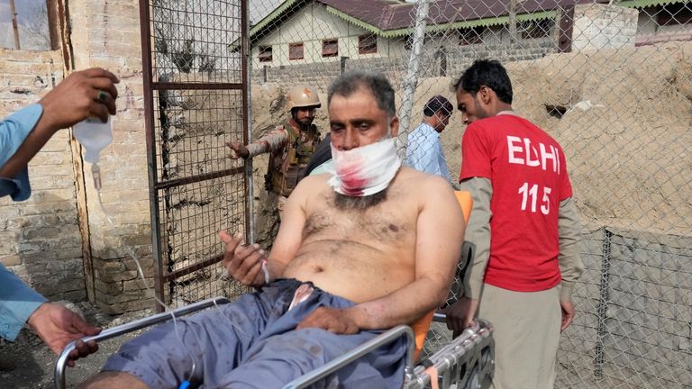 An injured passenger rescued by security forces. Pic: AP