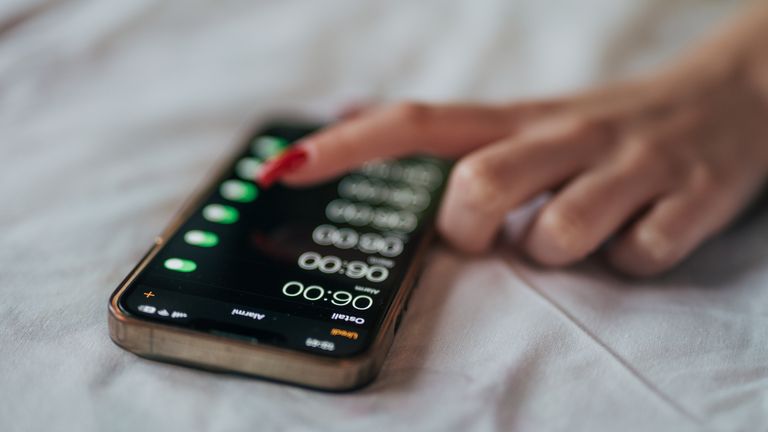 Woman turning off phone alarm clock. File pic: iStock