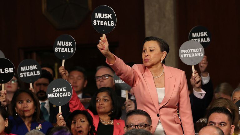 Protest signs at Trump speech. Pic: Reuters