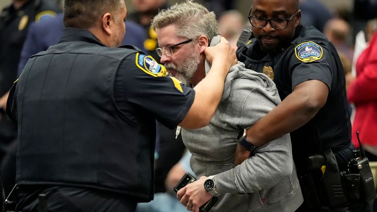 A protester is removed as Rep. Marjorie Taylor Greene, R-Ga., speaks during a town-hall style meeting, Tuesday, April 15, 2025, in Acworth, Ga. (AP Photo/Mike Stewart)