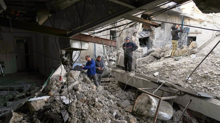 Staff inspecting the damaged hospital. Pic: AP