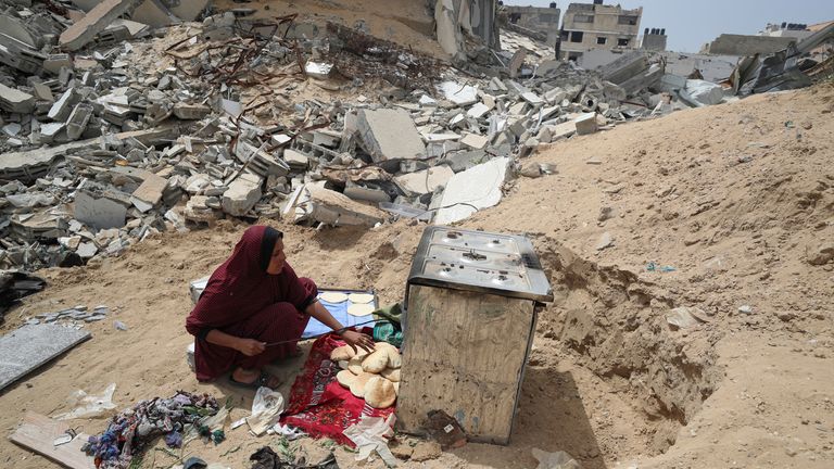 A woman bakes bread in an oven in Gaza City. Pic: Reuters