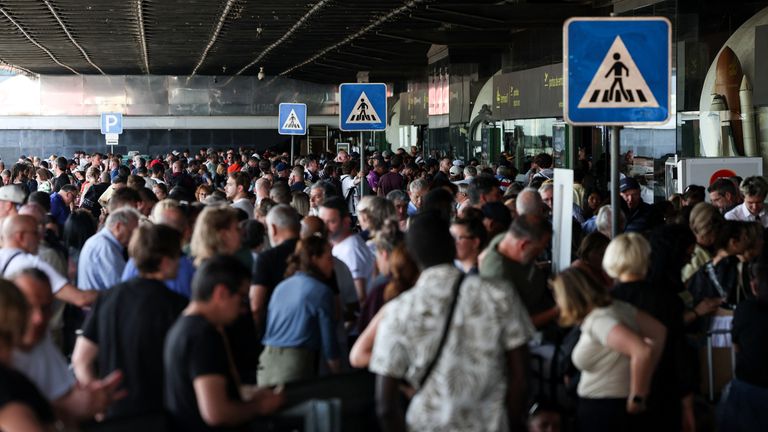 People wait outside a terminal at Lisbon Airport during a power outage which hit large parts of Portugal, in Lisbon, Portugal, April 28, 2025. REUTERS/Pedro Nunes