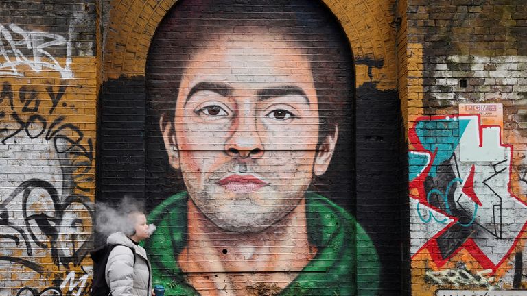 A pedestrian walks past a mural of Luigi Mangione in east London, the UK. Pic: Reuters