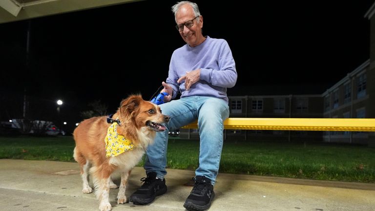 Carmine, of Waretown, and his dog Amber sit outside an evacuation center at Southern Regional High School during wildfires on Tuesday, April 22, 2025, near Stafford Township, N.J. (AP Photo/Chris Szagola)