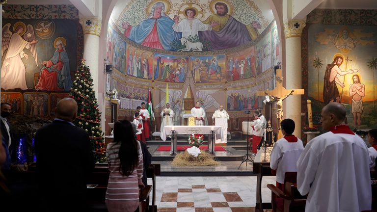 Father Gabriel Romanelli, Latin parish priest of the Gaza Strip, centre, conducts midnight Christmas Eve mass in Gaza City in 2021.  Pic: AP/Adel Hana