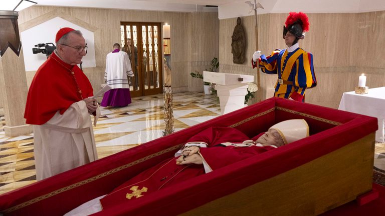 Vatican Secretary of State Cardinal Pietro Parolin, left, prays in front of the body of Pope Francis laid out in state inside his private chapel at the Vatican, Monday, April 21, 2025. (Vatican Media via AP, HO)