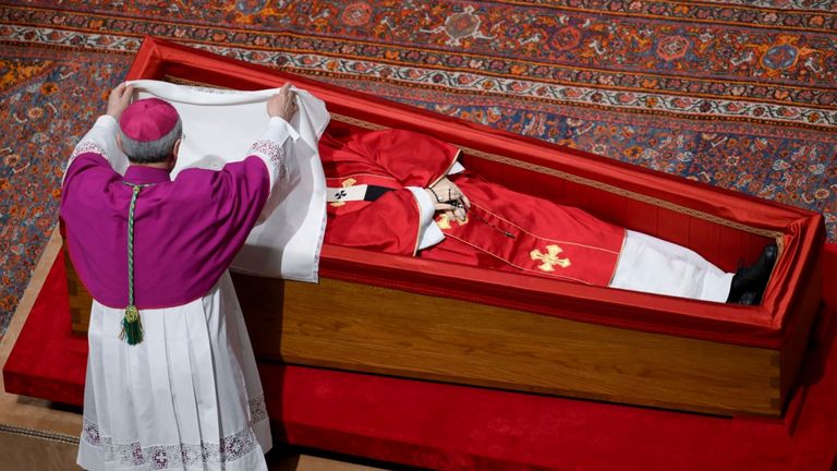 The Vatican's master of ceremonies covers the face of the Pope with a silk cloth before closing his casket. Pic: AP