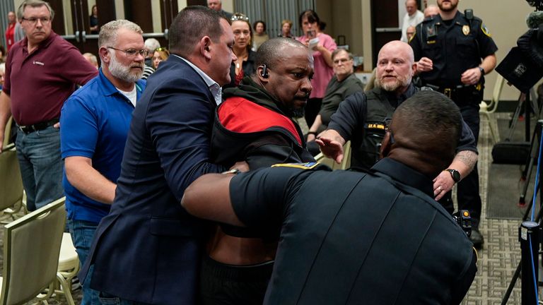 A protester is removed before a electronic non-leathal device was used as  Marjorie Taylor Greene.  Pic: AP