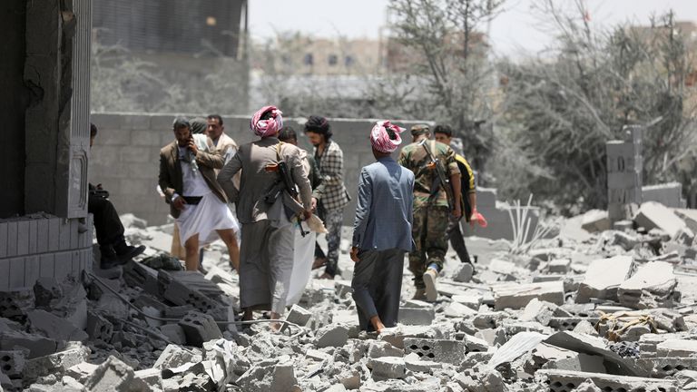 People stand on the rubble of a building destroyed by US air strikes in Sanaa, Yemen. Pic: Reuters