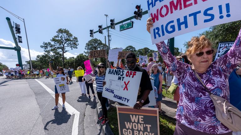 Activists protest President Donald Trump, who was a few miles away at his Trump National Golf Club, during a "Hands Off!" demonstration Saturday, April 5, 2025, in Palm Beach Gardens, Fla. (AP Photo/Alex Brandon)