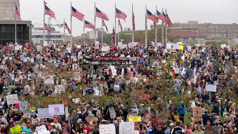 Demonstrators hold up their banners during a 'Hands Off!' protests protest against President Donald Trump at the Washington Monument in Washington, Saturday, April 5, 2025. (AP Photo/Jose Luis Magana)