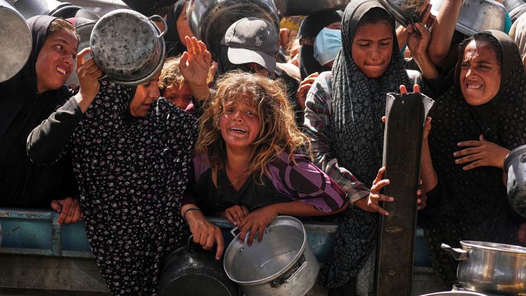Palestinians struggle to get donated food at a community kitchen in Khan Younis. Pic: AP