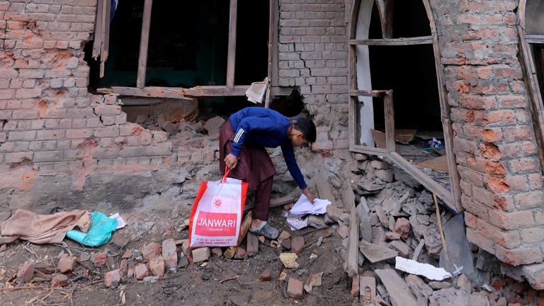 A boy collects papers from the debris of a residential house damaged by a cross-border shelling in Gingal village near the Line of Control (LoC) between India and Pakistan, in Indian Kashmir's Baramulla district, May 9, 2025. REUTERS/Stringer