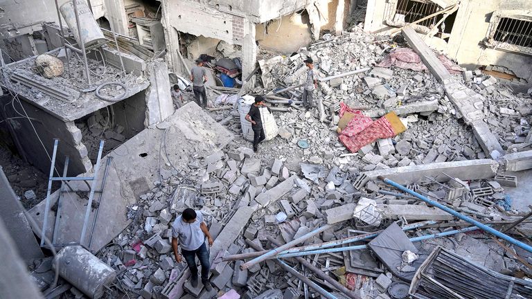 Palestinians inspect the rubble of homes destroyed by Israeli airstrikes in Jabalia, northern Gaza Strip, on Wednesday, May 14, 2025. According to local hospitals, 48 people were killed in the strikes, including 22 children. (AP Photo/Jehad Alshrafi)