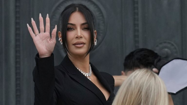 Kim Kardashian waves as she arrives to testify regarding a robbery of millions of dollars in jewels from her Paris hotel room in 2016, in Paris, Tuesday, May 13, 2025. (AP Photo/Aurelien Morissard)