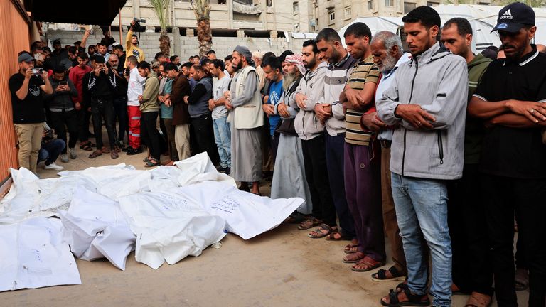 People stand next to the bodies of Palestinians who were killed in Israeli strikes during their funeral, at Nasser hospital in Khan Younis, southern Gaza Strip, May 15, 2025. REUTERS/Hatem Khaled