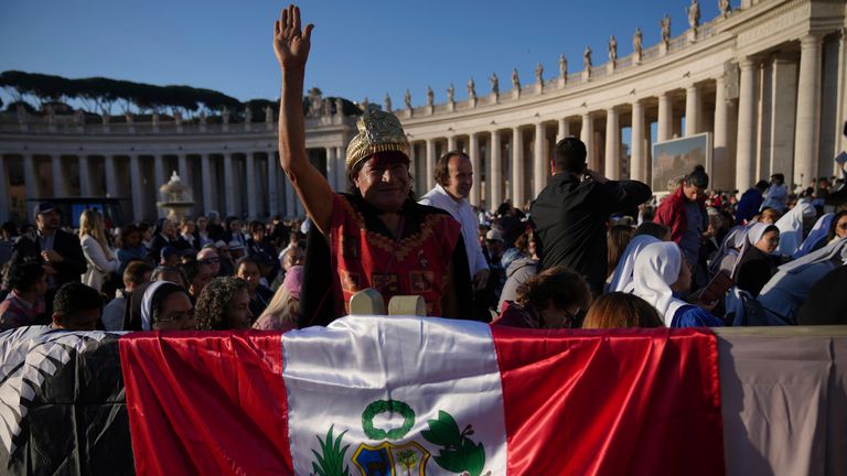 A member of the crowd displays the Peruvian flag. Pic: AP