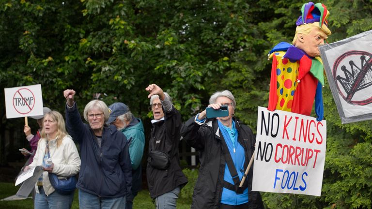 Demonstrators protest near Trump National Golf Club before the arrival of the president.   Pic: AP/Rod Lamkey Jr