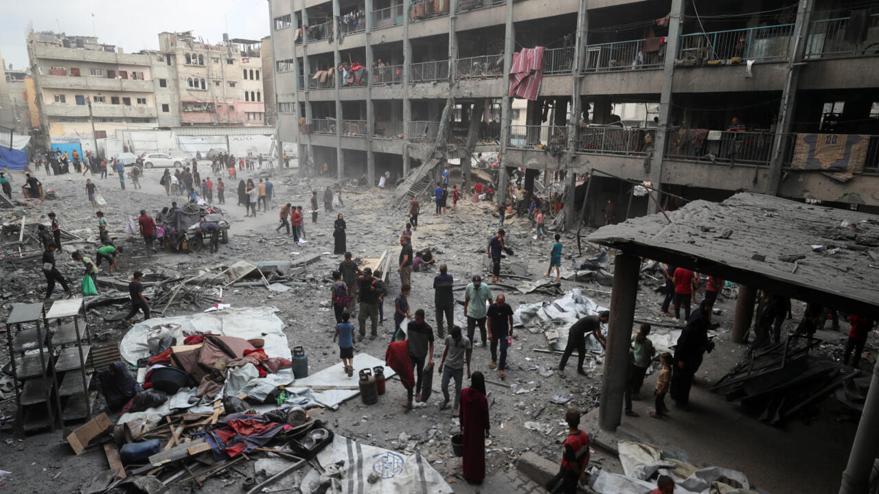 Palestinians inspect the damage at an UNRWA school sheltering displaced people that was hit in an Israeli air strike on Sunday, in Gaza City, June 30, 2025.
